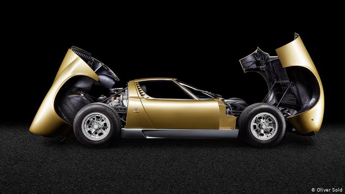 Lamborghini Miura P400 in gold metalic color. The front and rear cowls are widely opened.