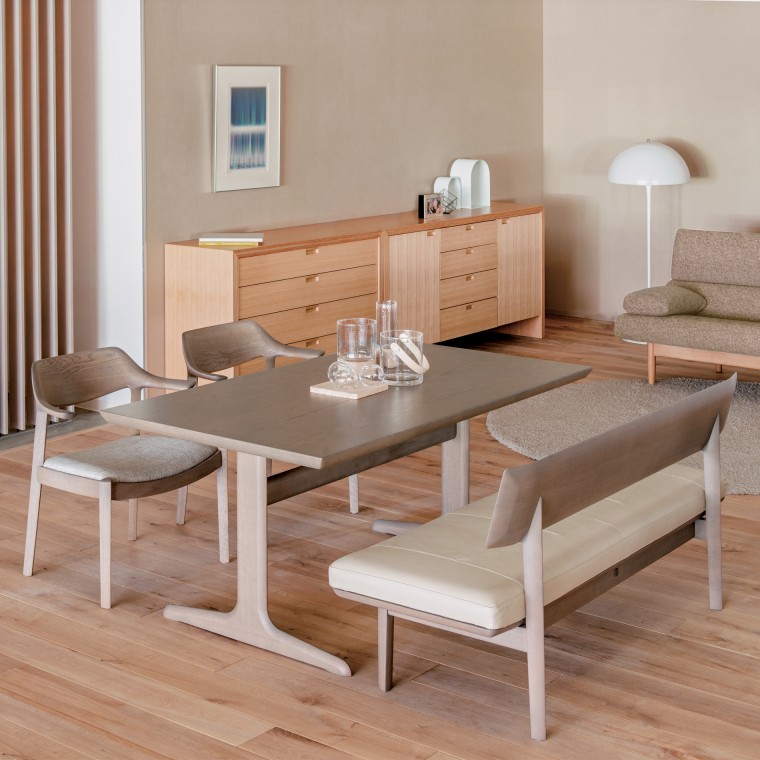 A dining set displayed in our headquarters shop. The set consists of a dining table, two dining chairs, and a bench.