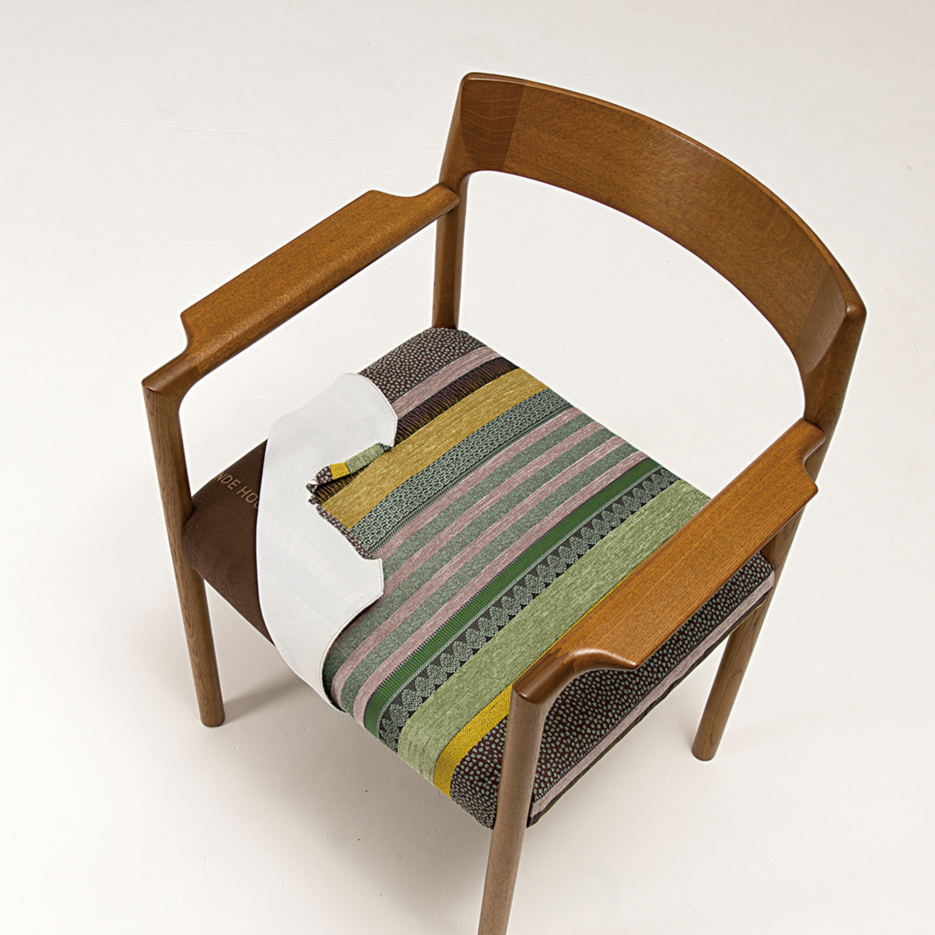 A wooden dining chair. The colorful seat cover is partially flipped to show it's replaceable.