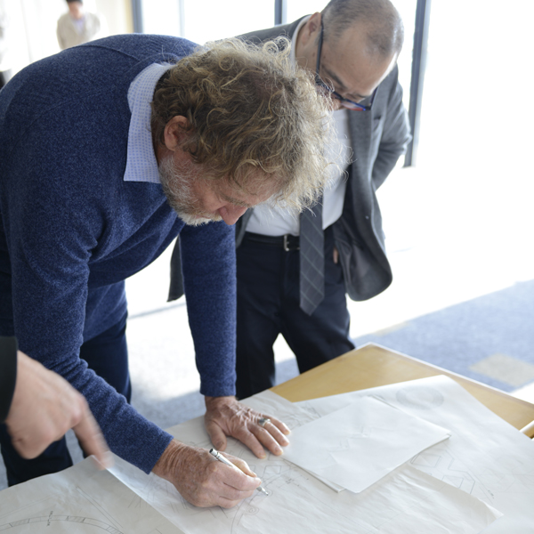 The discussion between a designer and our product development team over some draft drawings on the table.