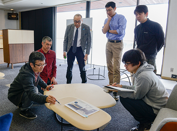 Our presiden and product development team are discussing the details of a new table with the designer.