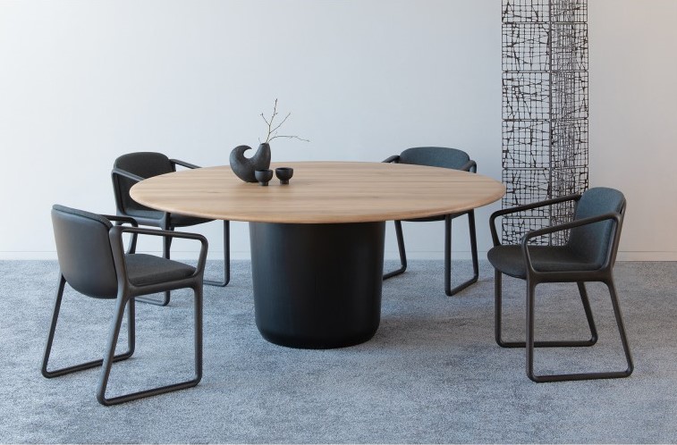 A round table with four dining chairs. The table top is made of oak in natural color.