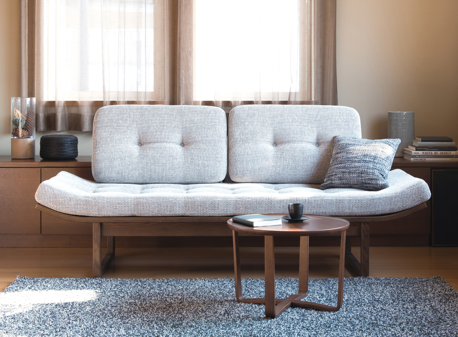 A bench that looks like a sofa as well, upholstered in the gray fabric.