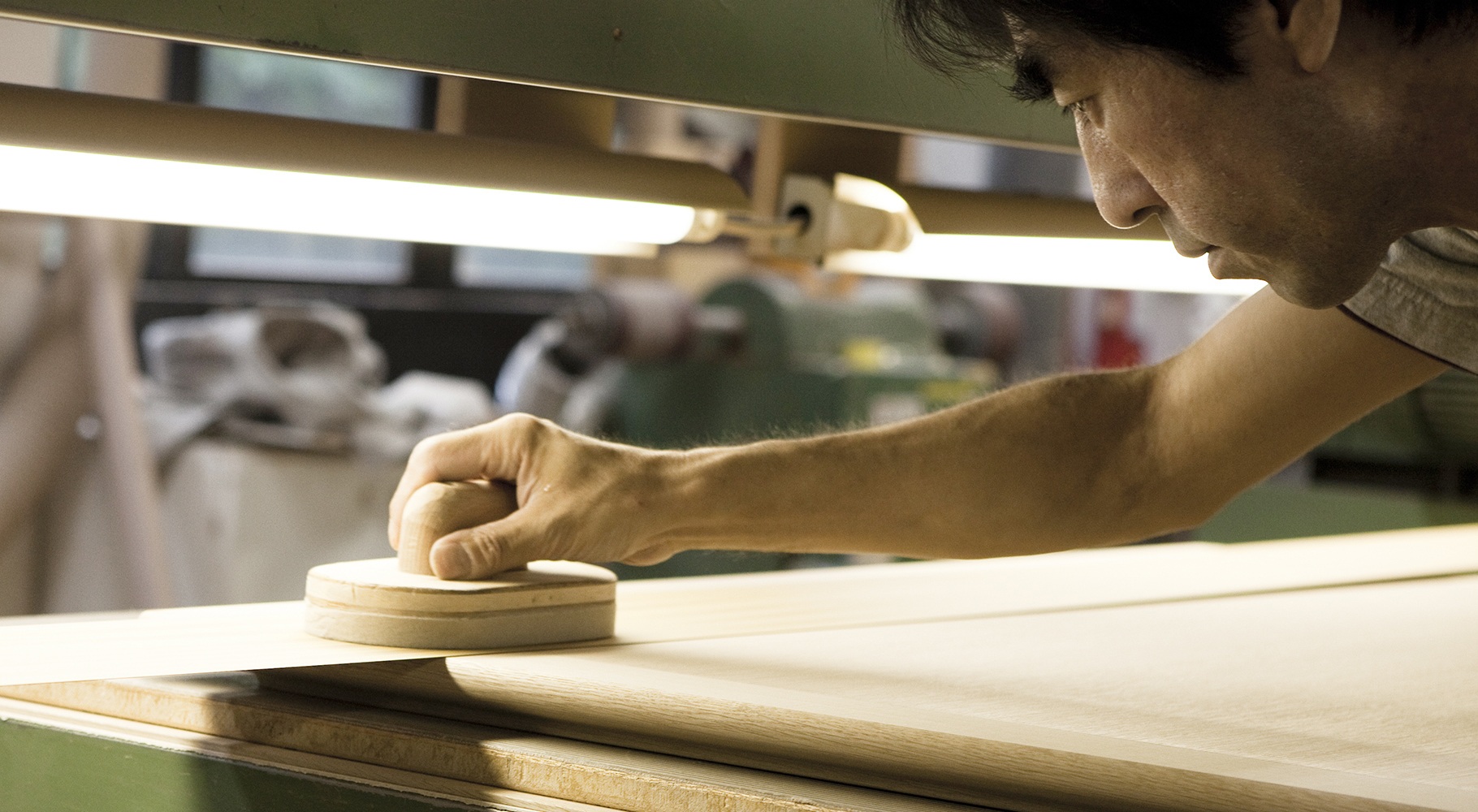 Our factory staff is sanding the surface of a dinint table.