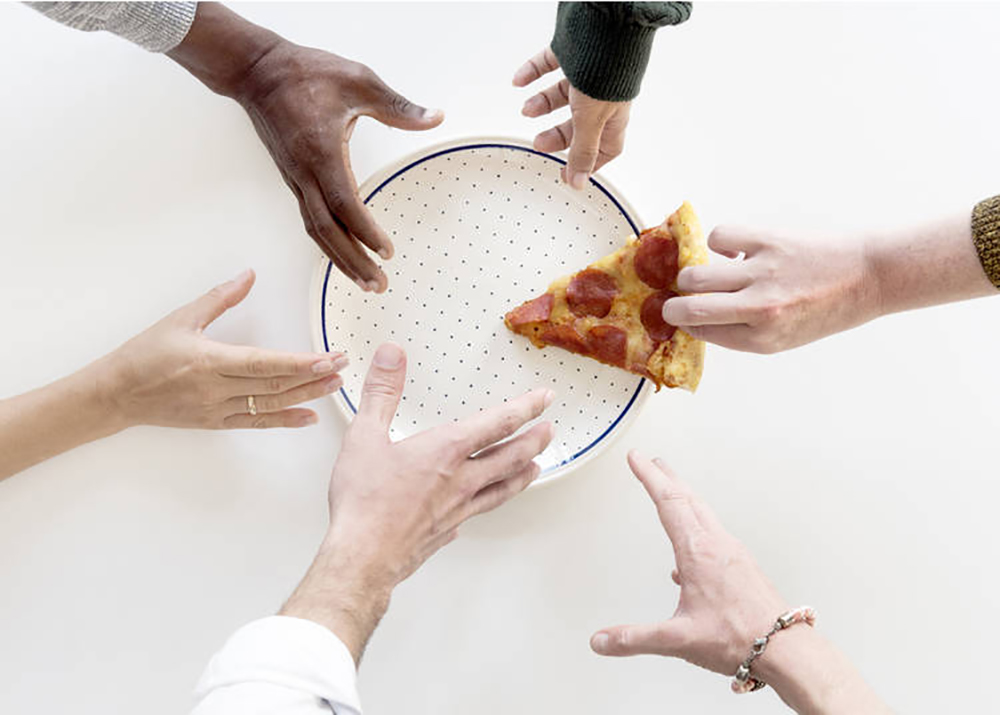 One piece of pizza is on the plate. Six hands reaching to a last piece of pizza.