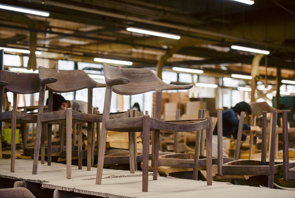 A line of wooden chair frames under process. It's an image in our furniture factory.