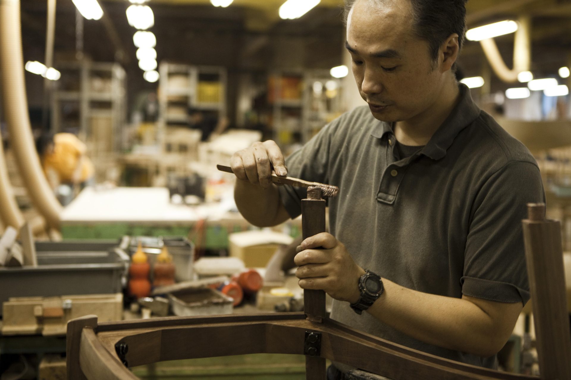 Our craftsperson is applying glue to the joint of the chair frame.