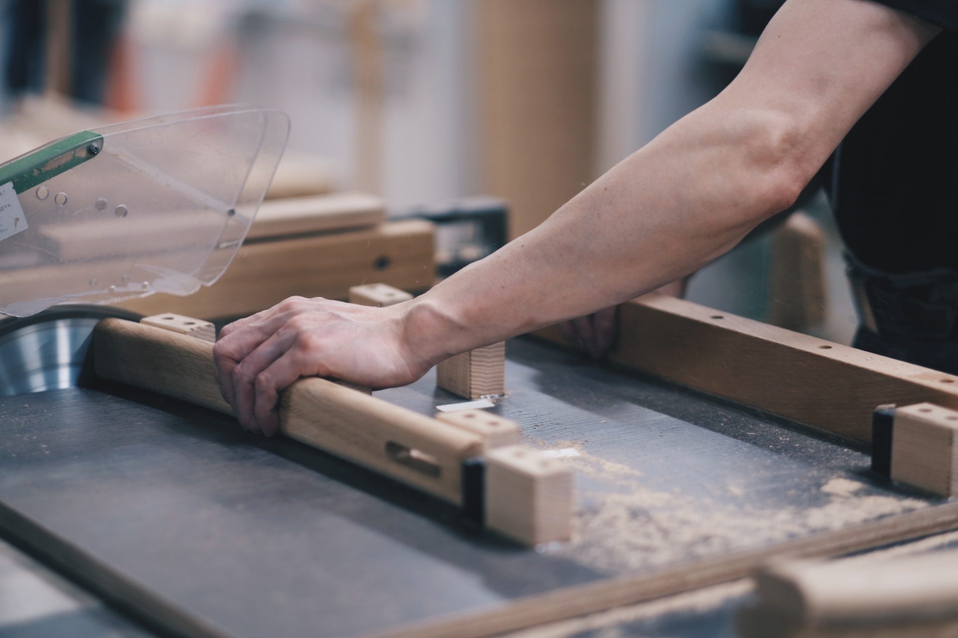 Our craftspeople set a wood piece on the table of a CNC machine. Preciseness is also required.