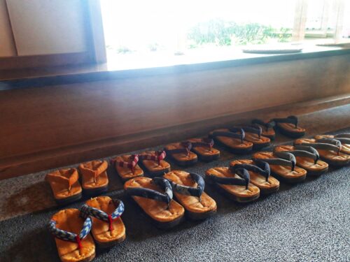 In a Japanese traditional hotel (ryokan), there are traditional woode nclogs are aligned neatly.
