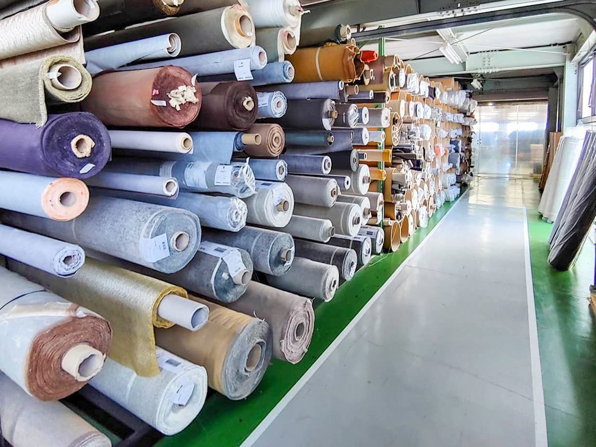 Many rolls of carpets on one side of a path in our factory.