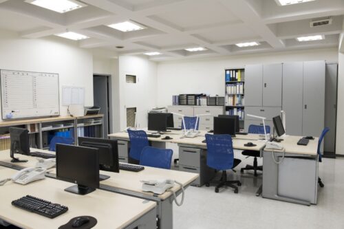 The scenery of a Japanese common office with gray desks and cabinets