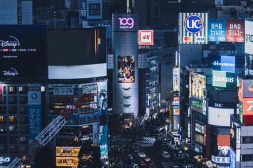 Shibuya crossing and 109 building lighted up by many neon signs at night