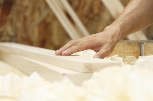 A craftsman's hand touching wood