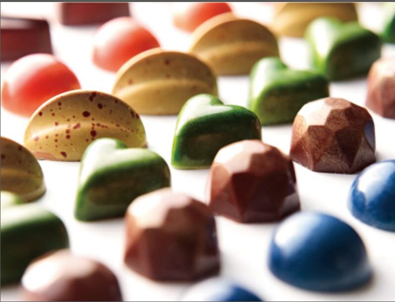 Colorful chocolates are aligned on a white plate