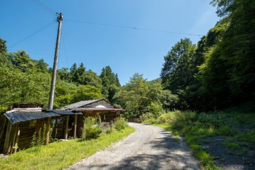 An abandoned house on a gravel road in a small village