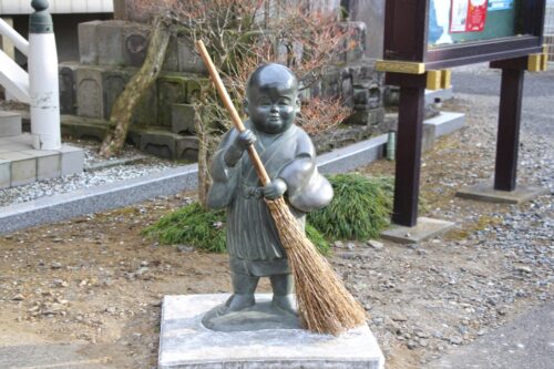 A statue of a boy holding a broom