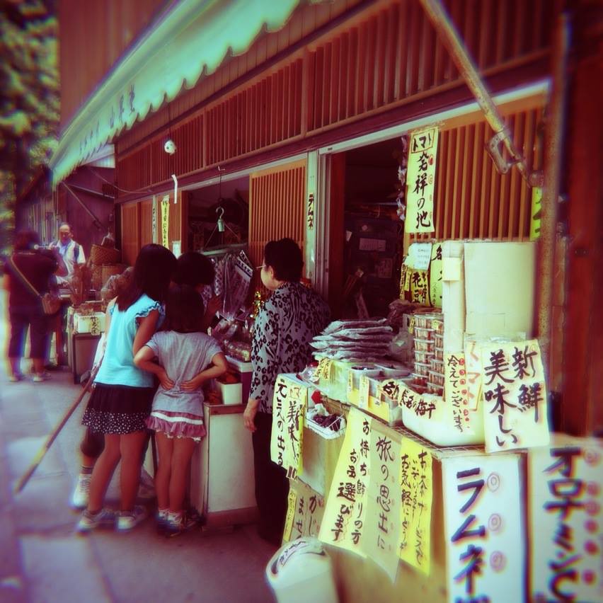 Some kids gathered in front of a candy shop.