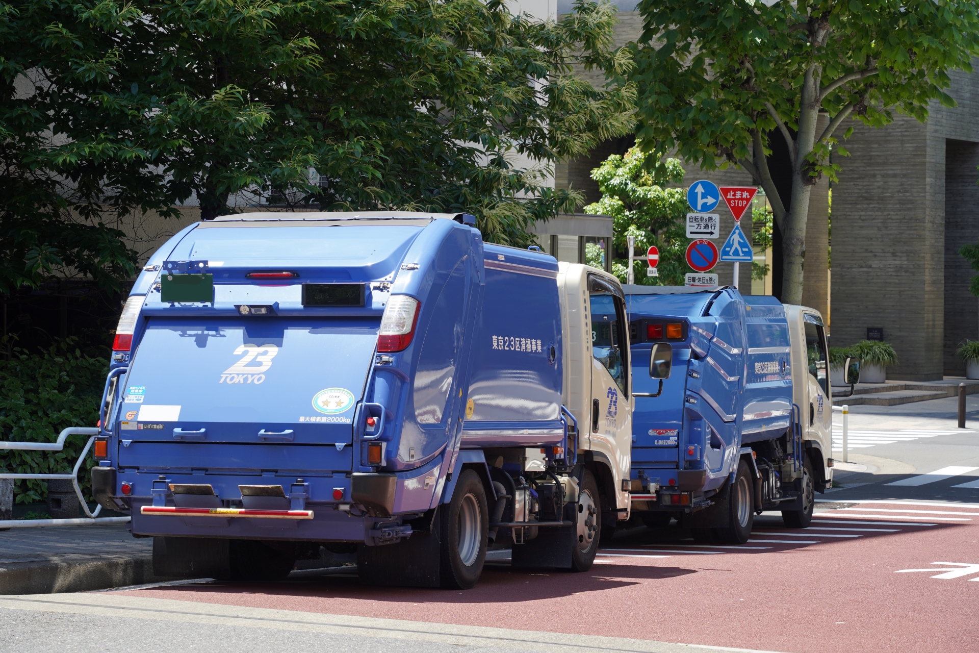 Two garbage trucks are parked on the road.