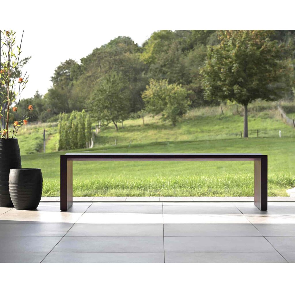 A wooden bench, simple but elegant design. It is placed by the huge glass window.