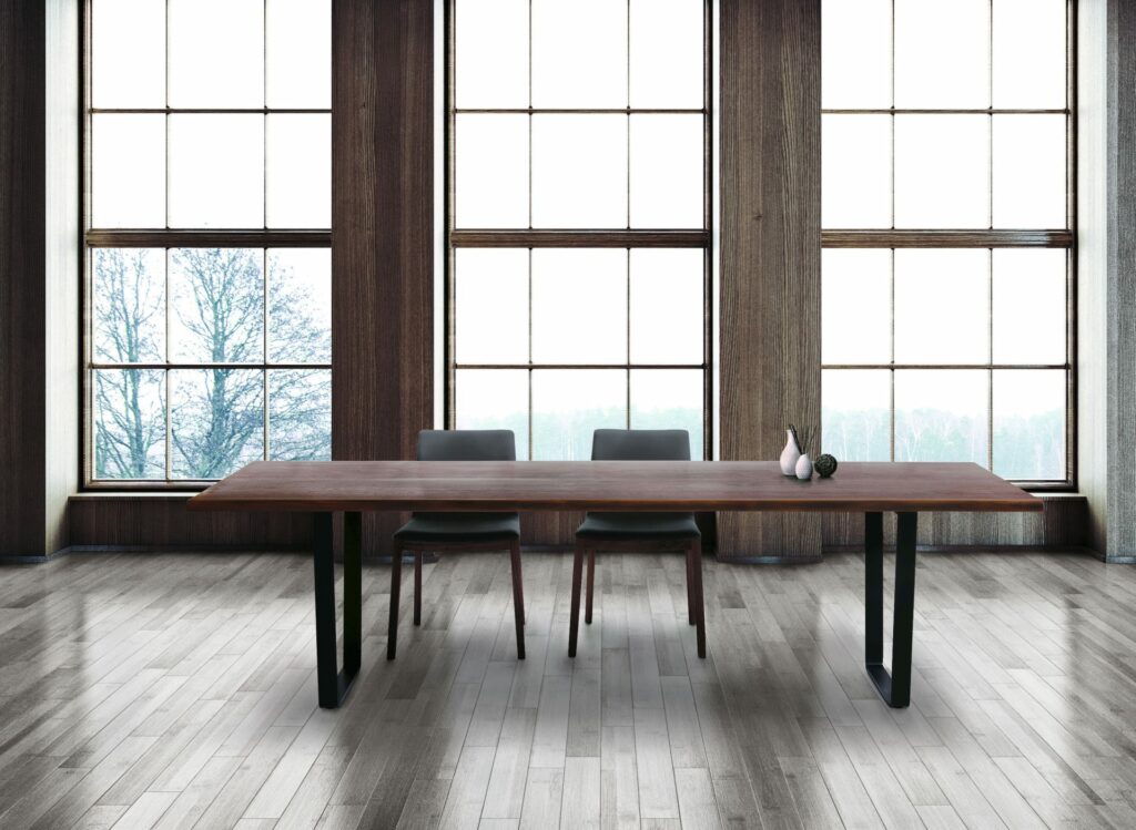 A table and chairs in a hotel room, and a snow field can be seen from the window.