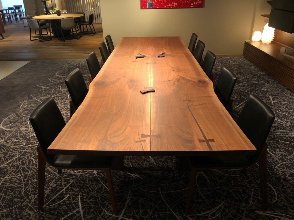 A beautiful huge wooden table with five chairs on each side.