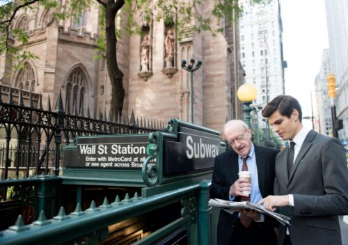 Two guys in a suit on the Wall Street at the subway station entrance