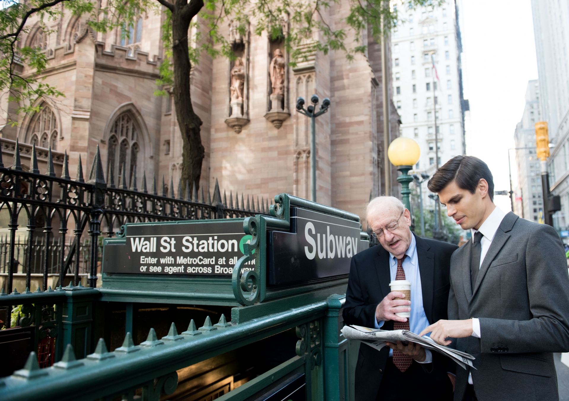 Two guys in a suit on the Wall Street at the subway station entrance