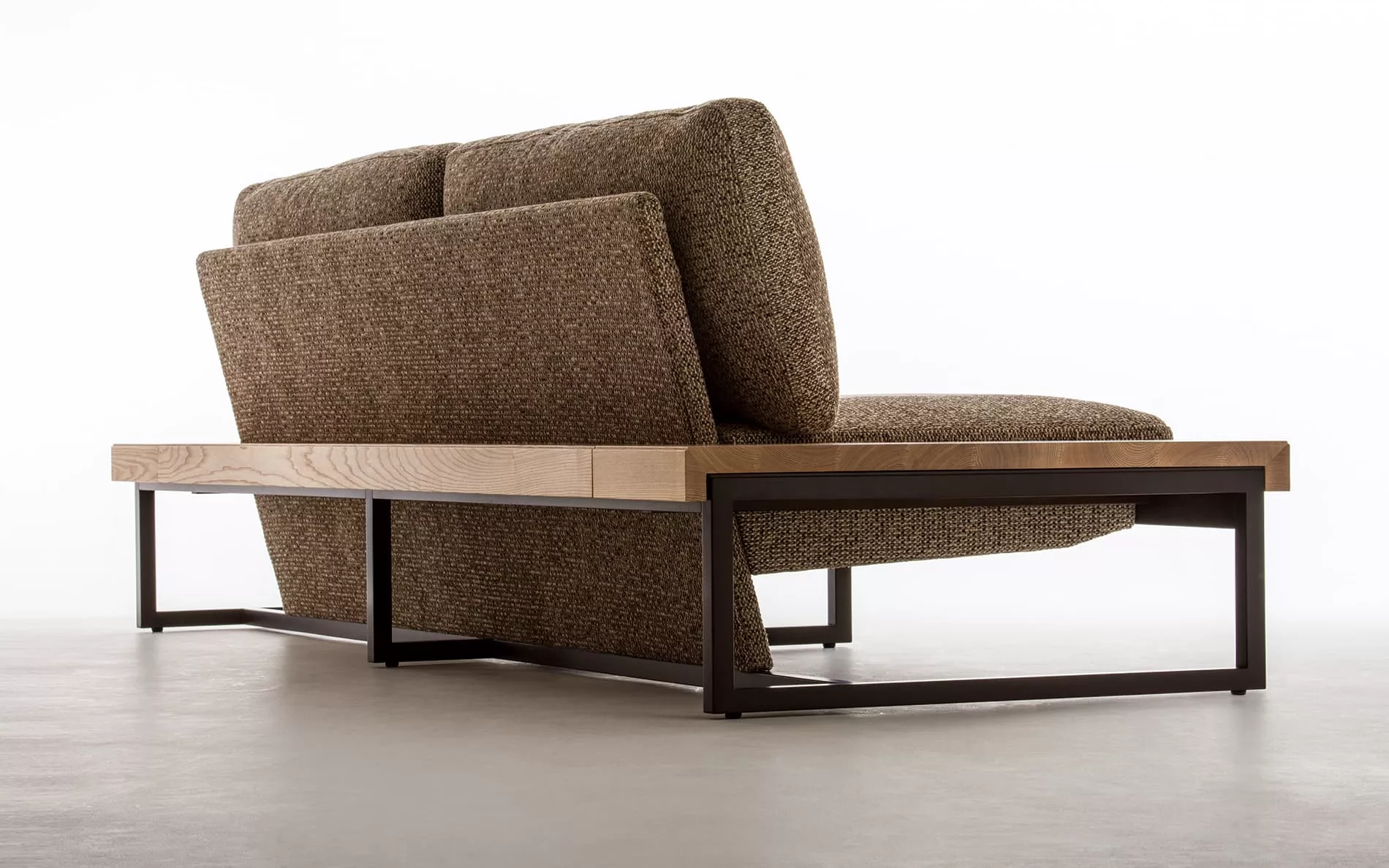 The back shot of a sofa with a wooden frame.