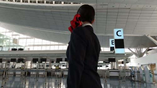 A femal cabin crew staring at airline counters in an airport