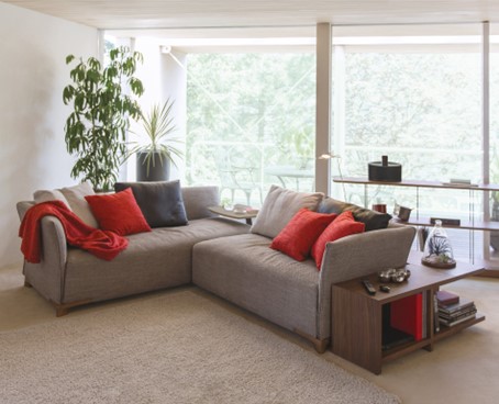A sofa set upholstered with gray fabric, on which there are many colorful cushions