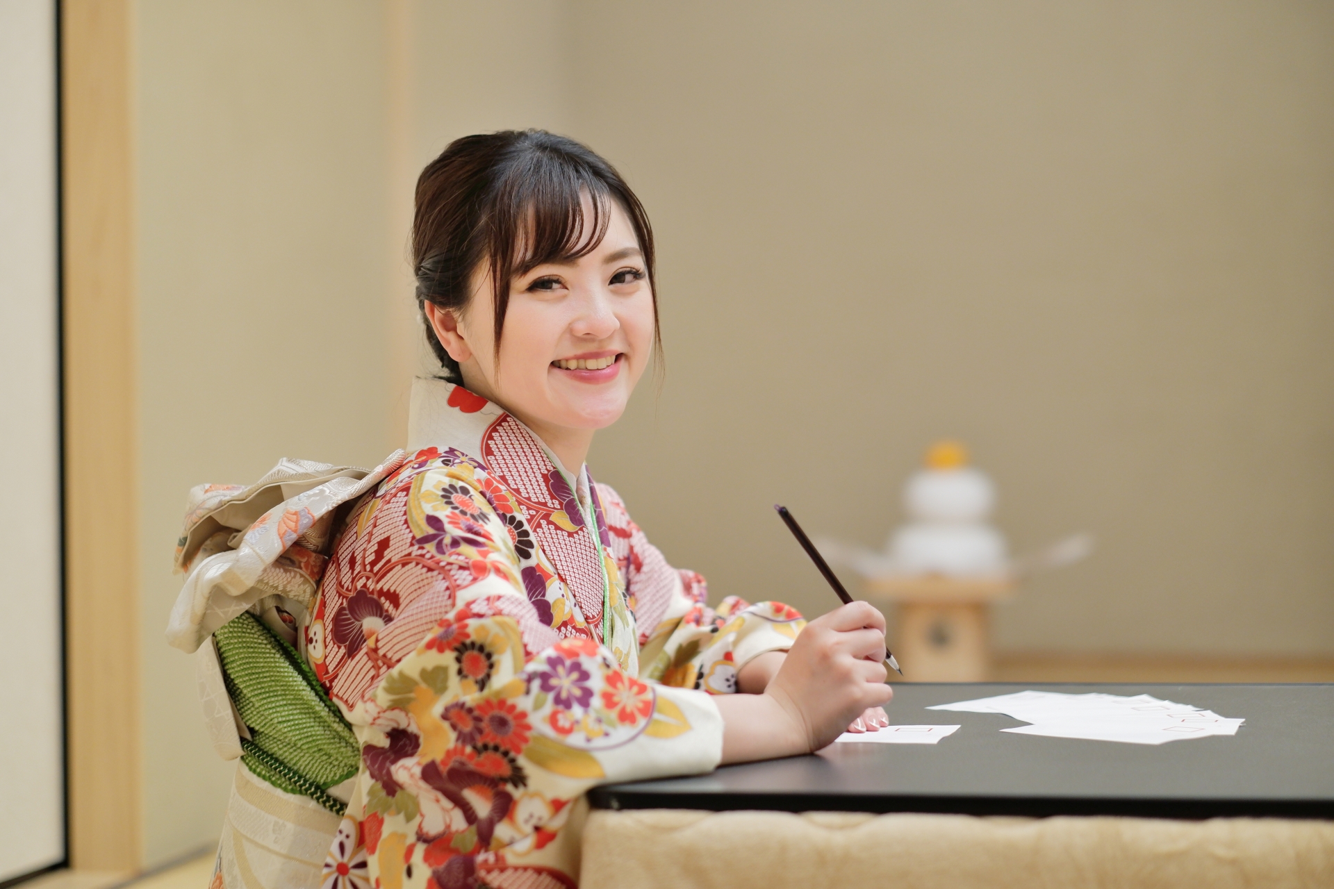 A woman wearing kimono is writing new year's greetings cards.